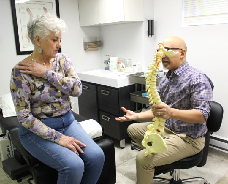 Chiropractor explaining spine model to patient